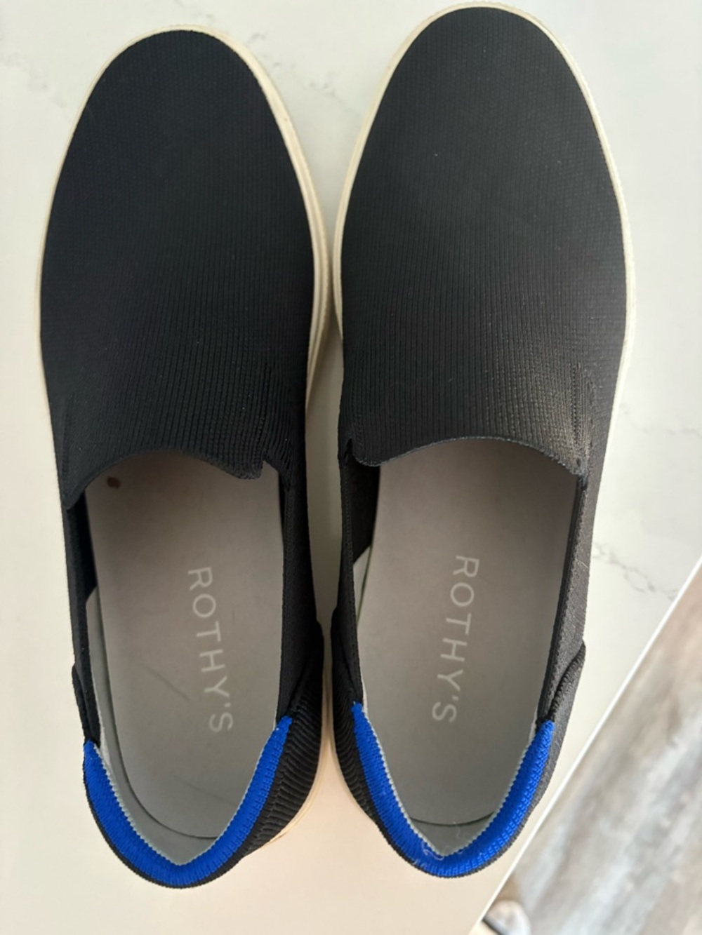 Rothy's  Women’s Black Original Slip-On Sneakers with the Signature Blue Trim